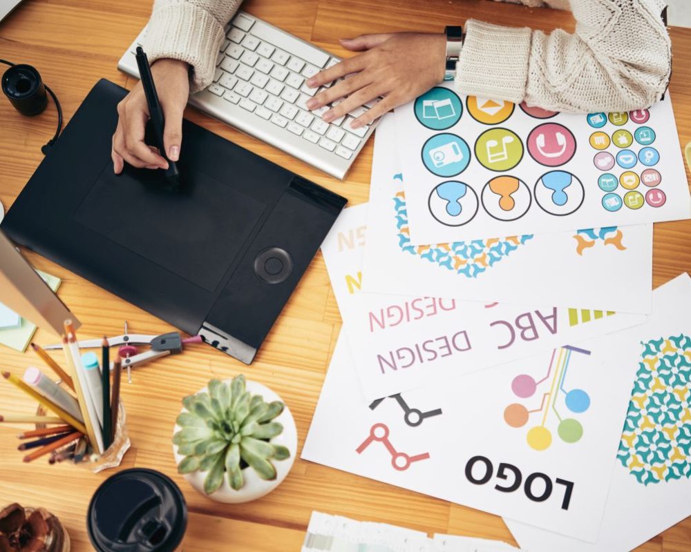 Diseñador gráfico creando identidad visual con tableta digital en Rebloom Studio